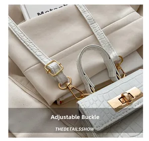 Detailed close-up of adjustable buckle and white crocodile texture on mini handbag