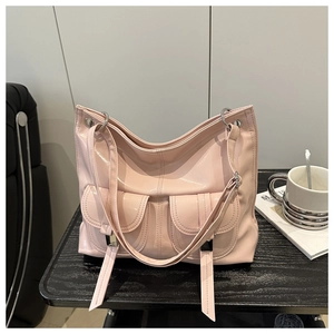Detail view of the pink faux leather tote bag with silver ring hardware and dual front pockets
