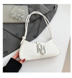 Détail d'un sac porté épaule blanc en cuir PU avec boucle argentée et nœuds minimalistes