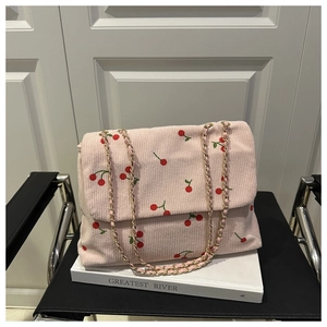 Détail d'un sac bandoulière en velours côtelé rose avec imprimé cerises