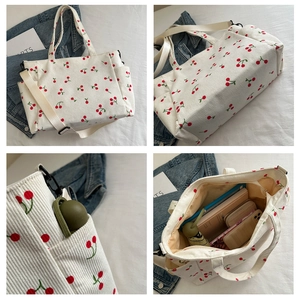 Détail du sac fourre-tout en velours côtelé blanc avec broderie cerise et poches latérales