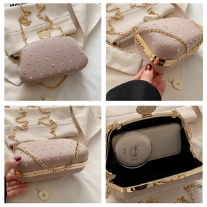 Detail view of pink embroidered evening bag with gold chain strap and interior storage