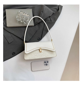Detail showing white sequin patchwork and golden wave quilted stitching on shoulder bag