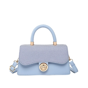 Light blue crossbody bag with denim flap, gold lock and leather handle for women