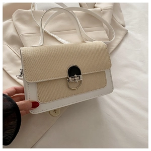 Detail showing beige woven texture with white faux leather stitching and silver clasp