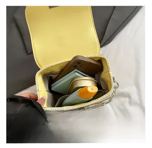 Close-up of the interior of this cream bow bag showing storage space for phone and makeup