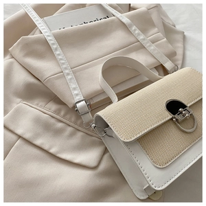 Close-up of beige woven and white leather patchwork handbag with metallic lock detail