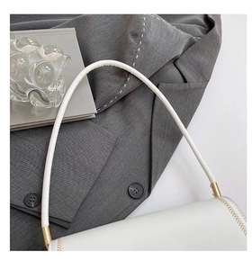 Detail of white PU shoulder bag with golden hardware and herringbone stitching accents