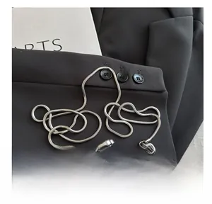 Detail einer herzförmigen silbernen Clutch mit Spiegelglanz und eleganter Schlangenkette