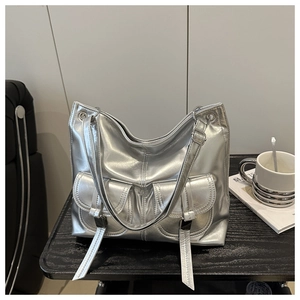 Detail of silver metallic tote bag featuring dual front flap pockets and adjustable straps