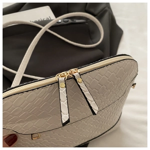 Detailed macro view of white crocodile pattern leather with premium golden zipper hardware