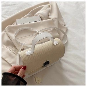 Close-up of beige woven texture and white leather flap with vintage metal buckle