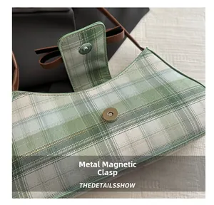 Close-up of secure magnetic snap closure on green checkered chic baguette handbag