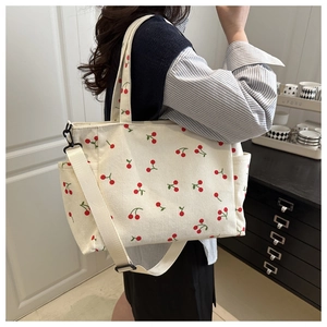 Détail du sac fourre-tout en velours côtelé blanc avec imprimés cerises et bandoulière