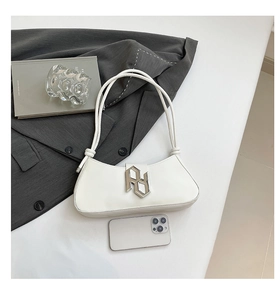 Détail du sac à bandoulière en cuir PU blanc avec une boucle géométrique en métal argenté