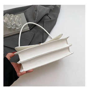Detail of the double compartment structure and fine stitching on the white shoulder bag
