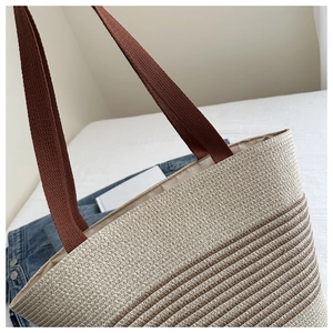 Detail of striped cotton rope woven tote bag with contrast brown handles and texture