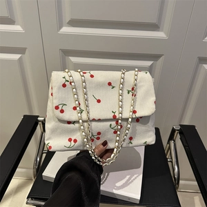 Sac bandoulière en velours côtelé blanc à imprimé cerises et chaîne dorée