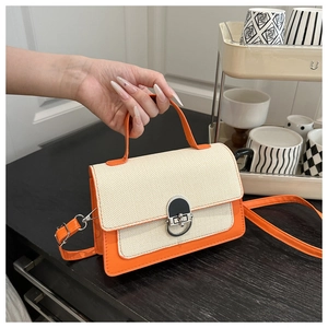 Detail view of stitched orange leather and beige woven fabric with metal buckle