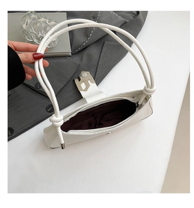 Vue détaillée du dessus d'un sac baguette en cuir PU blanc avec un fermoir en métal argenté