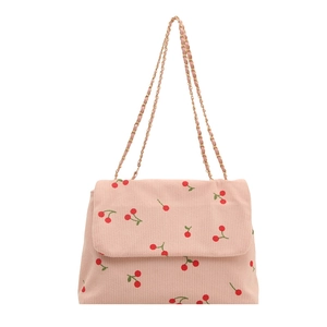 Sac à bandoulière en velours côtelé rose avec imprimé cerises et chaîne dorée sur fond blanc