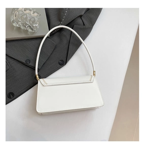 Detail view of white shoulder bag with gold stitching and minimal urban accessories