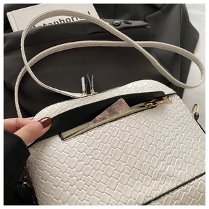 Detail of white woven crossbody bag with black zipper and internal zipped pocket