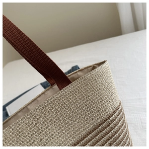 Detailed close-up of woven cotton rope texture and contrast stitching on a tote bag