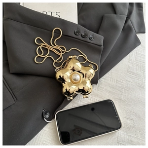 Detailansicht einer goldenen Blumen-Umhängetasche mit Perle und feiner Schlangenkette