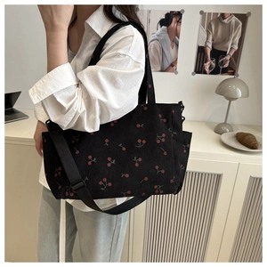 Photo lifestyle d'un sac cabas en velours côtelé noir avec motif cerise et sangle