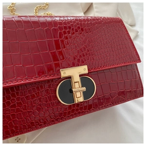 Detailed shot of red crocodile texture flap bag with luxury gold T-shape metal clasp