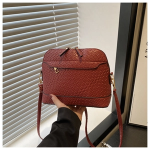 Detail of red-brown woven texture shell bag with golden zippers and slim shoulder strap