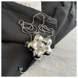 Detailansicht der silbernen Clutch in Blumenform mit großer Perle und Schlangenkette