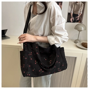 Détail du sac cabas en velours côtelé noir à imprimé cerises avec poches latérales