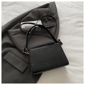 Detail of black crocodile-embossed PU leather bag with premium gold hardware and shoulder strap