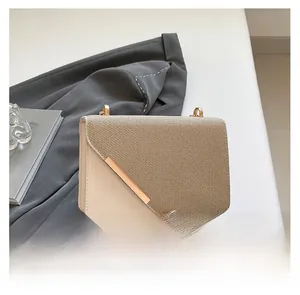 Détail du sac bandoulière montrant la texture sergé beige et la boucle dorée
