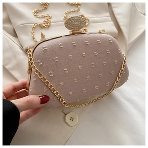 Detail of grey-pink textured jacquard evening clutch with sparkling rhinestone buckle