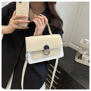 Close-up of minimalist square crossbody bag with beige texture and white leather patchwork