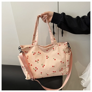 Détail du sac fourre-tout en velours côtelé rose avec imprimé cerise et poche