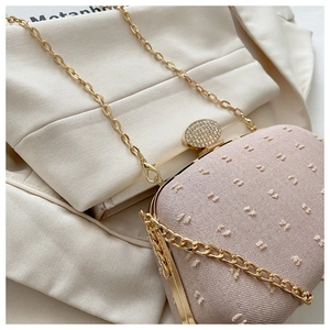 Close-up of pink jacquard evening clutch with diamond-encrusted gold metal clasp