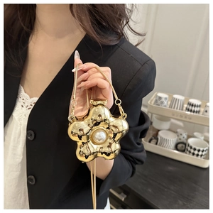 Detailansicht der goldenen Blumen-Minitasche mit Perle und eleganter Schlangenkette