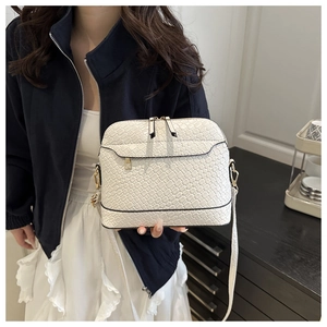 Detailed macro view of the white woven texture and golden metal zippers on the PU crossbody bag