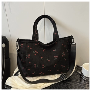 Détail du sac cabas en velours côtelé noir avec motif cerise et bandoulière réglable