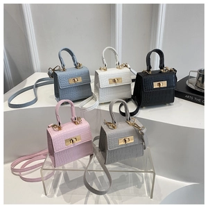 Detailed view of five mini faux crocodile leather handbags in various colors with gold hardware