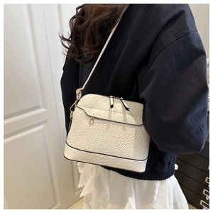 Close-up of white crocodile texture faux leather material on a shell crossbody bag