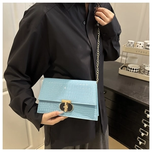 Model showing a light blue crocodile pattern chain bag with golden lock and strap