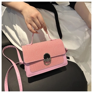 Detailed view of pink square bag featuring woven texture flap and silver metal clasp lock