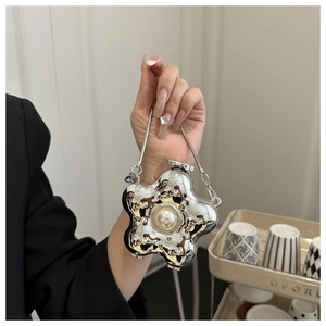 Detailaufnahme der silbernen Blumen-Abendtasche mit Spiegelglanz und großer Perle