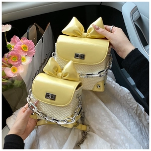 Detail of yellow bow flap leather woven bag with metal chain and turn-lock closure