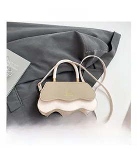 Detail of light pink scalloped bag with beige woven flap and gold logo hardware
